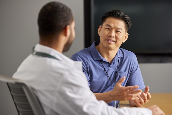 Intelas team members engaged in a focused conversation during a meeting in a clinical setting.