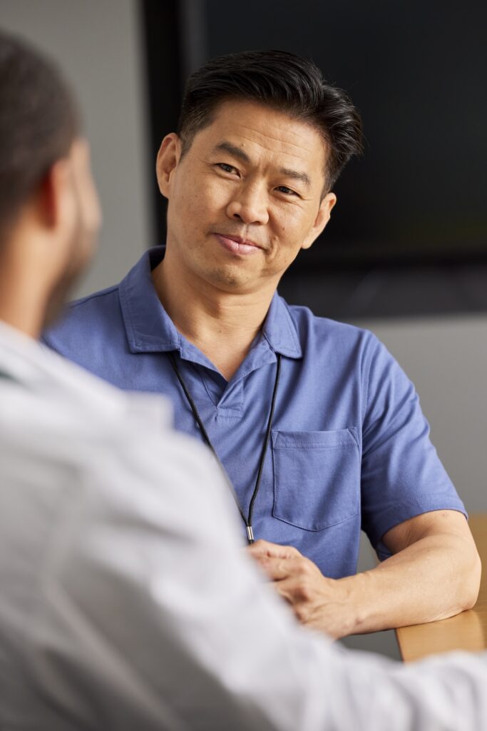 Intelas team members engaged in a focused conversation during a meeting in a clinical setting.