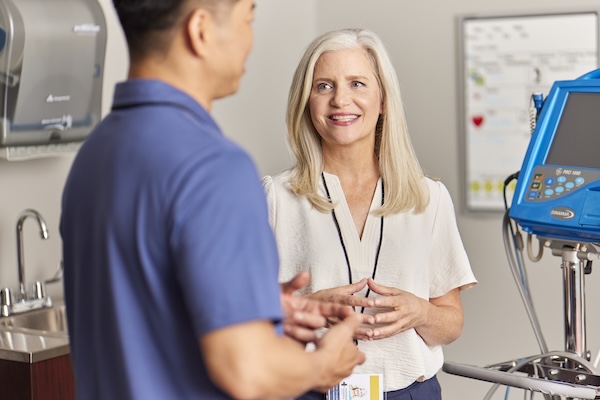Intelas team members having a friendly conversation in a clinical setting near medical equipment.